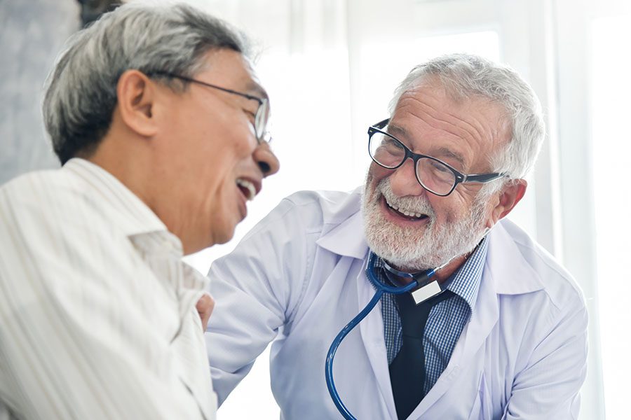 Medicare Part B - Smiling Doctor Doing a Checkup on a Cheerful Senior Man