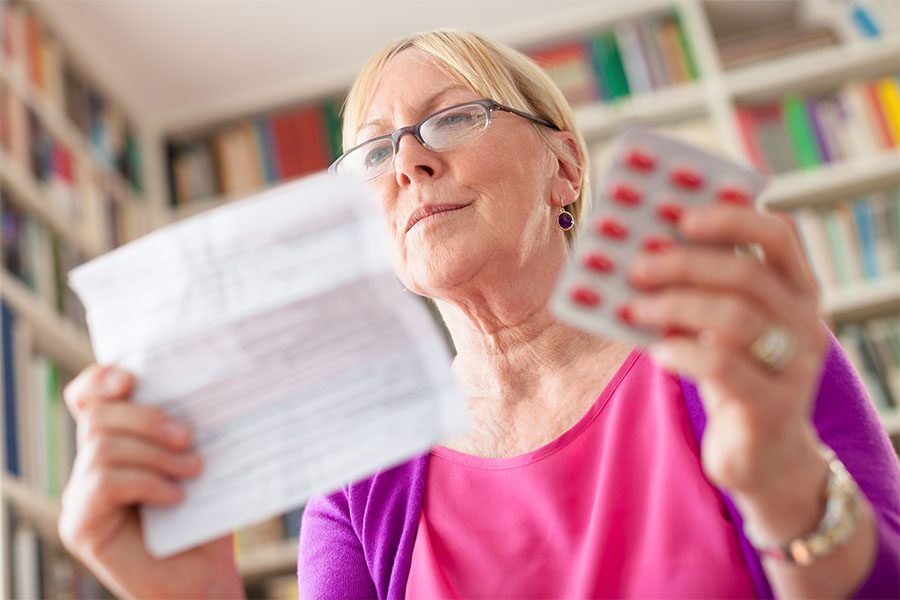 Medicare Part D - Elderly Woman at Home Reading Information About Her Prescription Medication